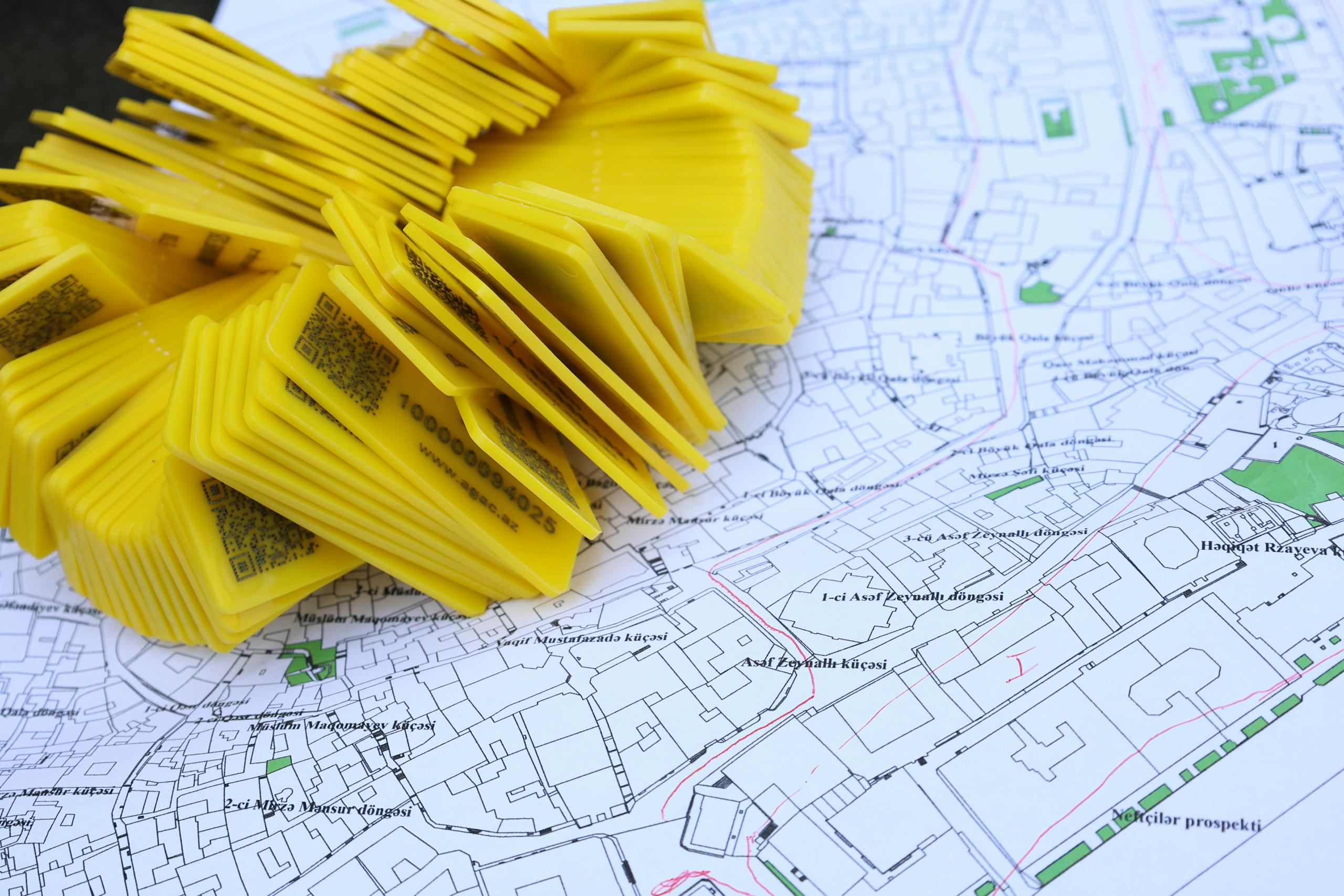 Stack of yellow QR code markers placed on a detailed map for location tracking and navigation.